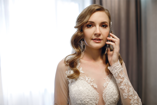 Image of a Young woman bride in a wedding dress talking on a phone