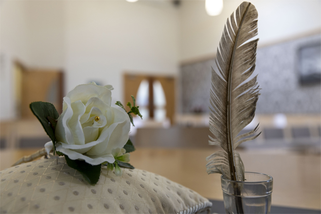 Image of a pillow and pen with a white rose.