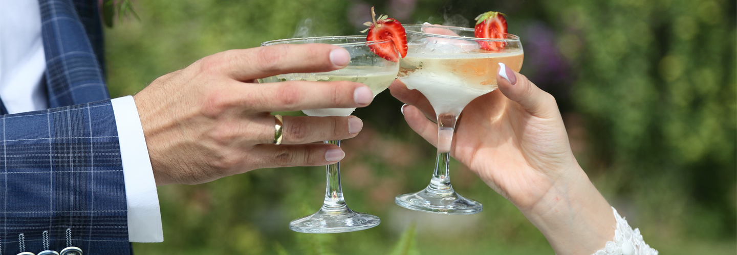 Image of a man and woman holding glasses together.