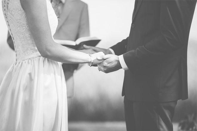 Image of a couple holding hands during their wedding.