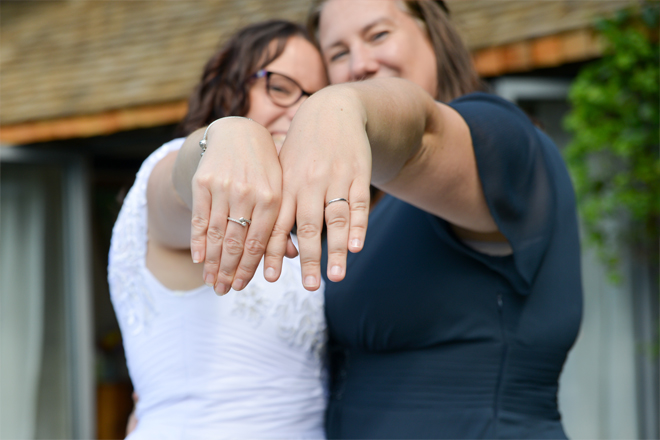 Image of a couple showing off their rings.