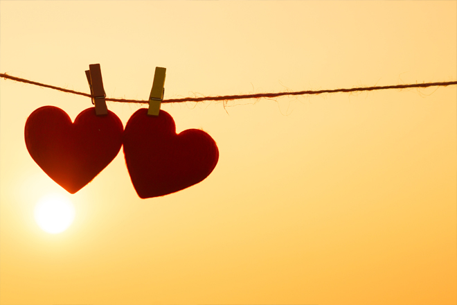 Image of a sunset and 2 red hearts.