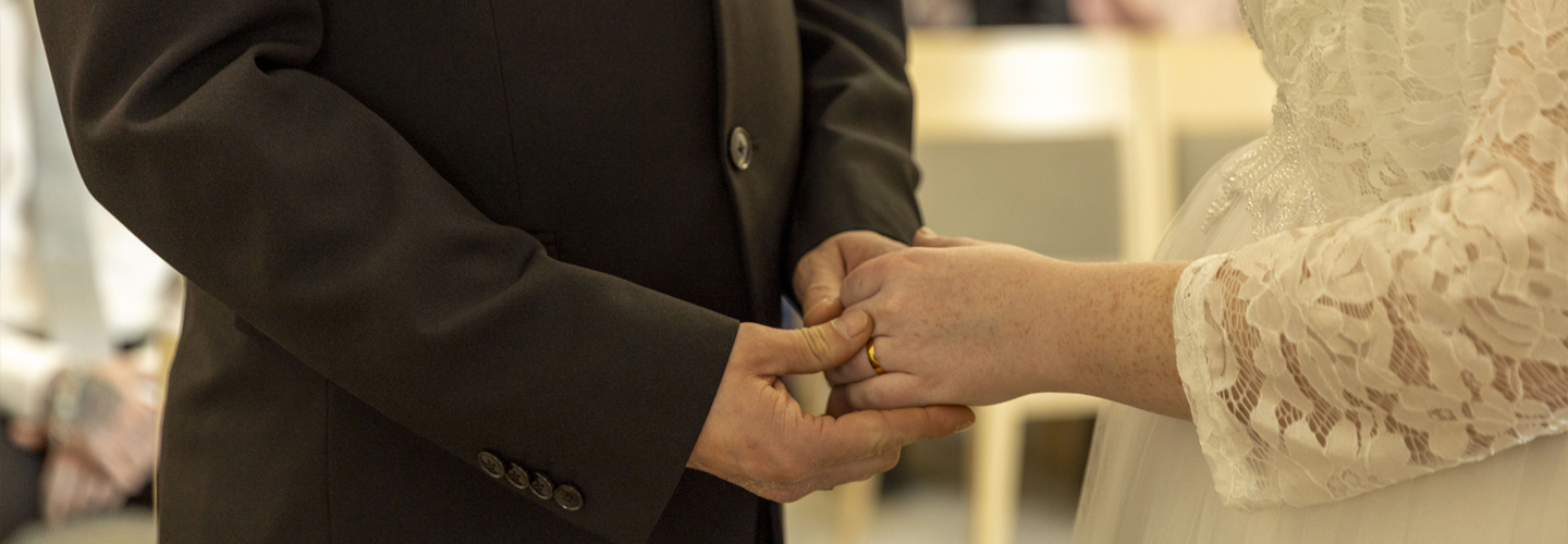 Image of a bride and groom holding hands.